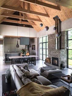 a living room filled with furniture and a fire place in the middle of an open floor plan