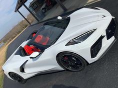 a white sports car parked in front of a building