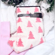 a pair of pink and white socks sitting on top of a bed next to a christmas tree