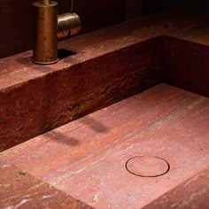 a close up of a wooden bench with a metal object on the ground next to it