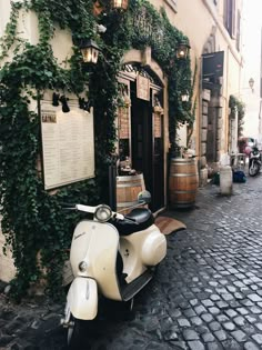 a scooter parked in front of a building with vines growing on the wall