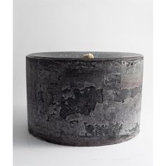 an old round metal container with a candle inside