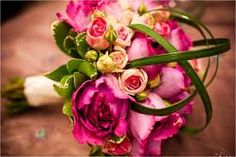 a bouquet of pink flowers sitting on top of a table