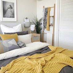 a bed with yellow blankets and pillows in a bedroom