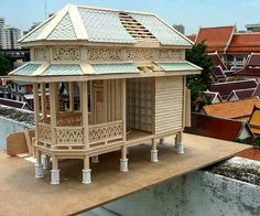 a small wooden house sitting on top of a roof