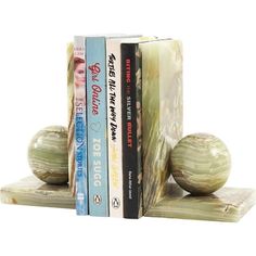 two bookends made out of marble with books on each side and one in the shape of a ball