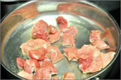 raw meat is cooking in a pan on the stove