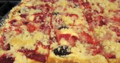 a close up of a pizza with cheese and strawberries on it's crust