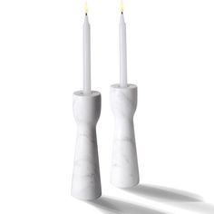 two white candles sitting next to each other