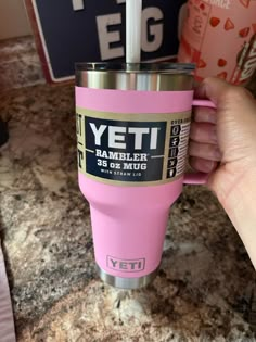 a person holding a pink yeti coffee cup