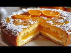 an orange cake is cut into slices on a white plate with powdered sugar and sprinkles