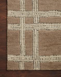 a brown and white rug on top of a wooden floor