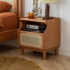 a nightstand with a lamp and pictures on it