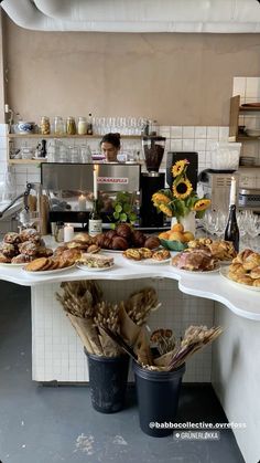 a table filled with lots of food next to a counter covered in breads and pastries