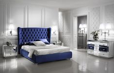 a bedroom with white walls and blue bedding, mirrored nightstands and mirror tables