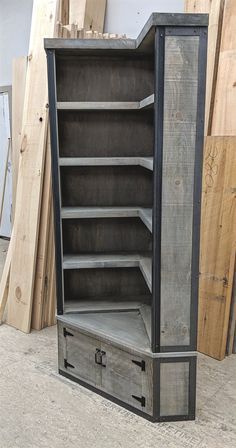 an old wooden storage cabinet sitting in front of some wood planks and plywood boards