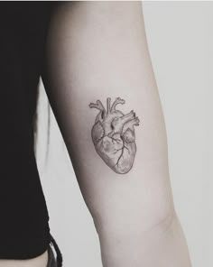 a small heart tattoo on the arm