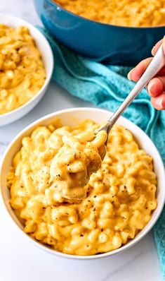 a person holding a spoon full of macaroni and cheese