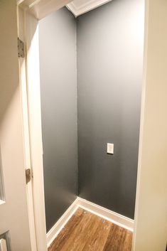 an empty room with hard wood flooring and gray paint on the walls in it