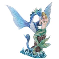 a statue of a mermaid sitting on top of a tree stump with a fish in it's mouth