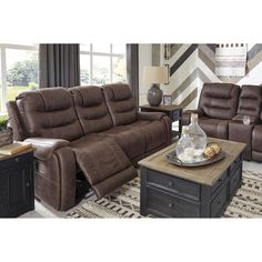 a living room with two recliners and a coffee table in front of the couch