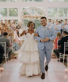 a bride and groom walking down the aisle