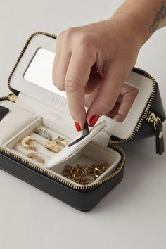 a woman's hand reaching into an open jewelry case