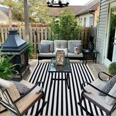 an outdoor living area with chairs, table and fire place