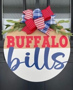 a sign that says buffalo bills hanging from the side of a black door with red, white and blue bows on it