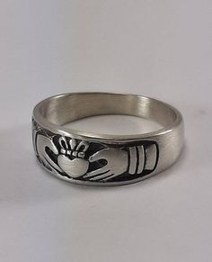 This is a stunning, hand-crafted Sterling Silver Claddagh. High polished, Brushed Satin or Oxidized. This is a  solid 925 sterling silver ring of great quality. Its intricate design creates a very unique and elegant look! Makes a beautiful ring for your loved one. Suitable for Men or Women.  Ring will arrive in a nice fitted jewelry box.    If you are interested in a ring like this with a heavier band.  click the link below https://www.etsy.com/listing/267120802/free-engraving-mens-wide-satin-sterling?ref=shop_home_active_1 The last picture where it shows the 3 finishes are pics of my slightly heavier claddagh ring. Please refer to pic #4 for the finishes. From left to right, high polish, satin, and oxidized.  Oxidized finish will gradually wear over time. 7mm wide at the heart/crown (top) Claddagh Ring Men, Mens Claddagh Ring, Beryl Ring, Double Rings, Turquoise Gold Ring, Heart Crown, Claddagh Ring, Viking Ring, Celtic Rings