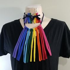 a woman wearing a black shirt with rainbow colored tassels on it