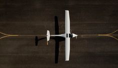 an aerial view of a small white airplane flying over the ground with two propellers on it's wings