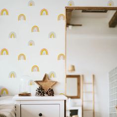 a white dresser sitting next to a wall with a wooden star on top of it