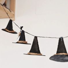 three black witches hats hanging from a string