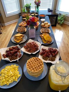 a long table topped with waffles and other breakfast foods