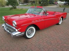 an old red car is parked on the street