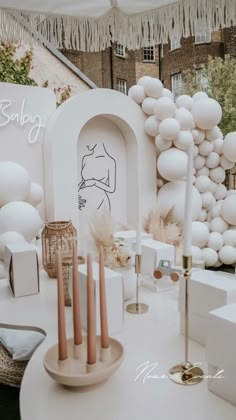 a white table with candles and balloons on it