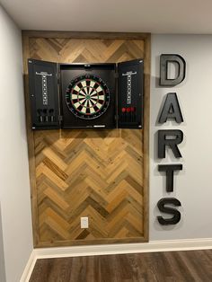 a darts sign mounted to the side of a wall next to a dart's board