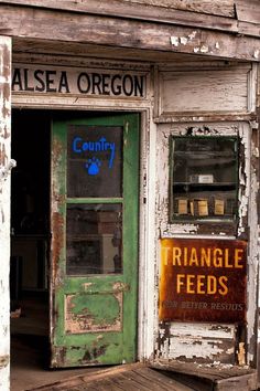 an old run down store front with peeling paint and broken doors that says triangle feeds