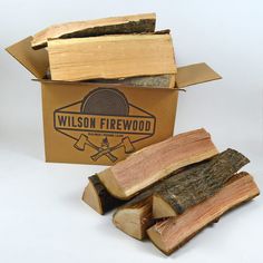 a box filled with lots of wood sitting next to a pile of firewood logs