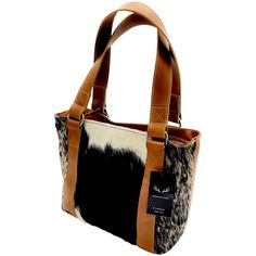 Handcrafted, Functional and Stunning. This eye catching handbag is meant for everyday functionality. The beautiful cowhide plus our top grain antique Buffalo saddle leather stands out in a crowd and is sure to be a show stopper. This handbag is just the right size to become your everyday bag that can be used for just about any of your needs. From day to night this bag is perfect! Please note as cowhide is a natural material each bag is one of a kind and the pattern will differ on each crossbody. Leather Stand, Saddle Leather, Handbag Black, Buffalo Leather, Leather Conditioner, Tote Handbag, Horse Hair, Everyday Bag, Natural Material