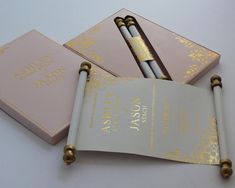 two pink and gold notebooks sitting on top of each other