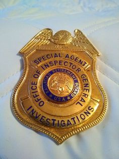 a police badge that is on top of a white shirt with blue and gold lettering