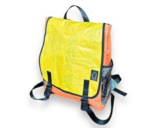 an orange and yellow backpack sitting on top of a white surface