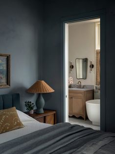 a bedroom with blue walls and a large mirror on the wall next to a bed