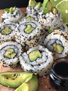 sushi rolls with avocado and sesame seeds on a cutting board