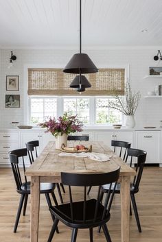 a dining room table with black chairs around it