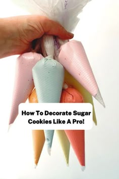 a person is holding some candy cones in front of their face and the words how to decorate sugar cookies like a pro