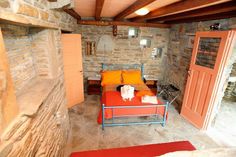 a bed sitting inside of a bedroom on top of a stone floor next to a doorway