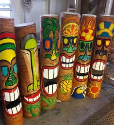 several colorfully painted tiki style vases lined up